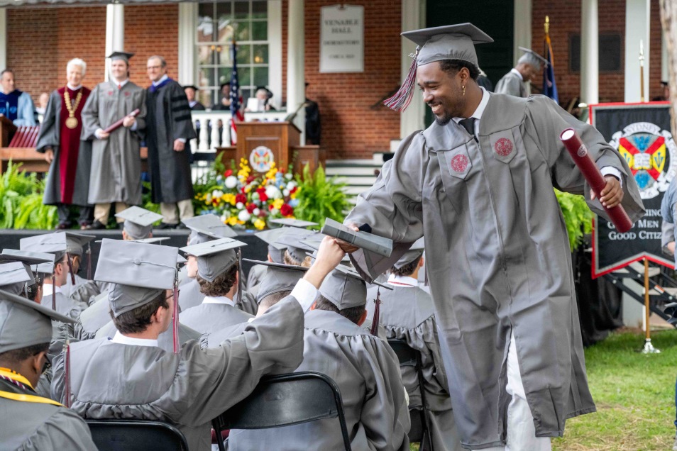 graduates fist-bumping at commencement ceremony