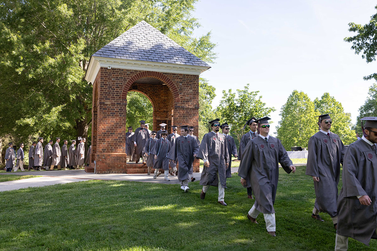 Class of 2025 in regalia processing through the Bell Tower