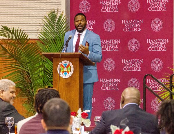 Hakeem Croom giving a speech behind a lecturn at H-SC
