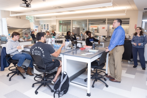 Students in a biology lab listening to their professor