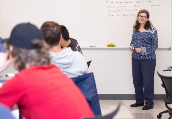 Professor smiling as she instructs a class of students