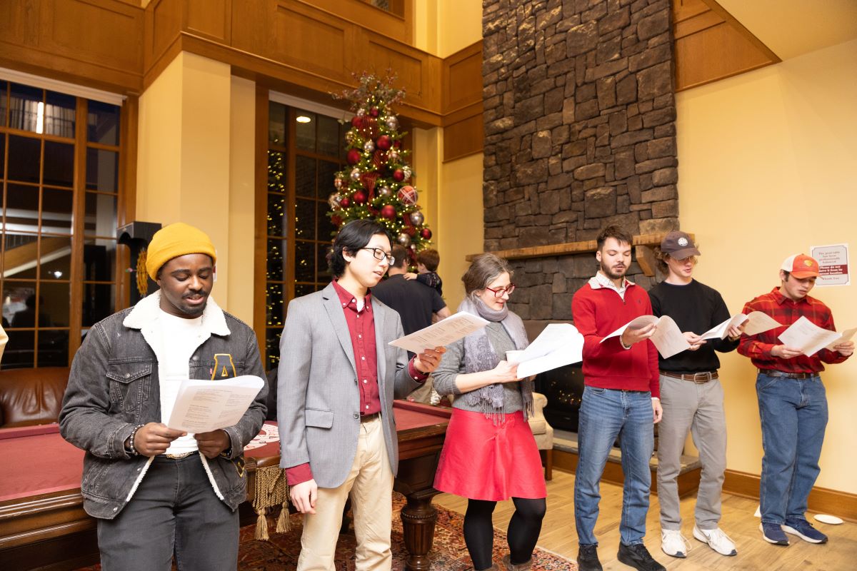 Students singing carols in the student center living room