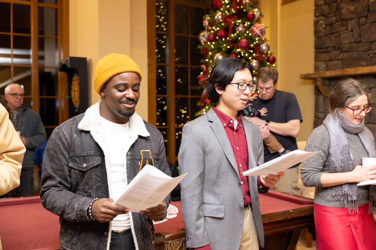 Students singing carols in the student center living room