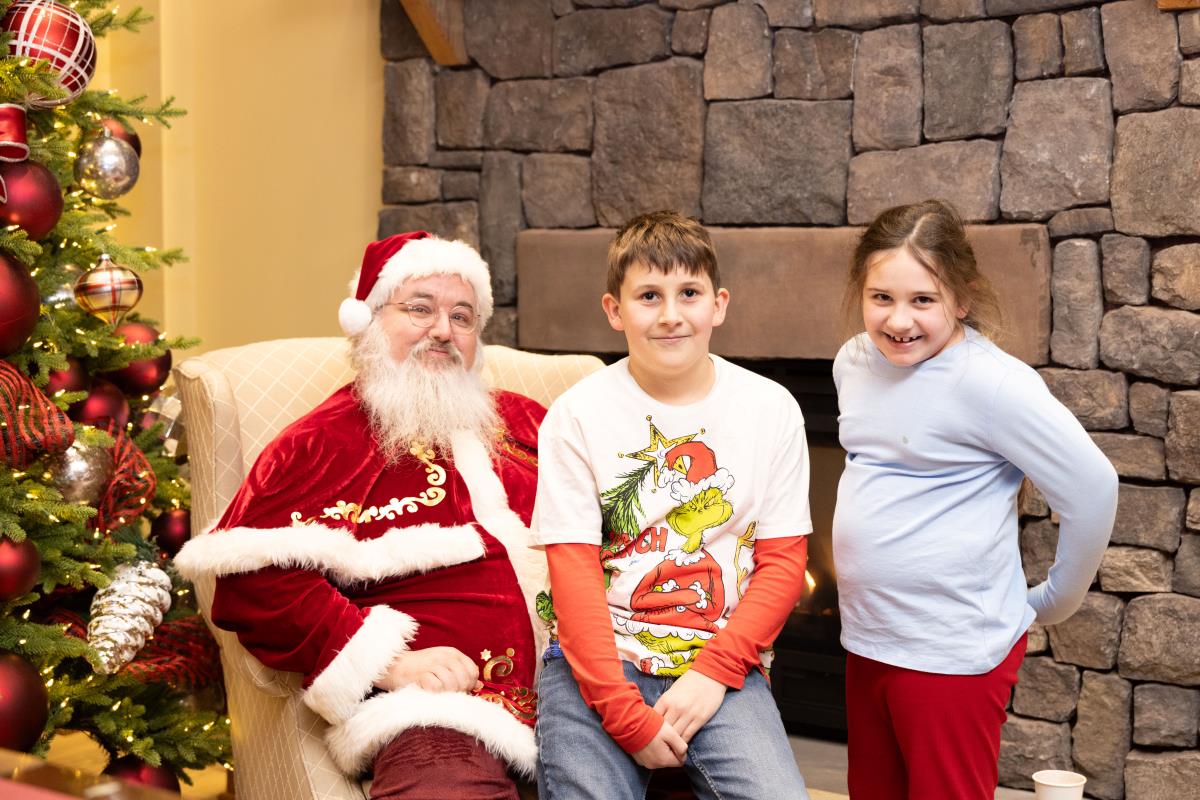 Santa and children posing for a picture in the student center living room