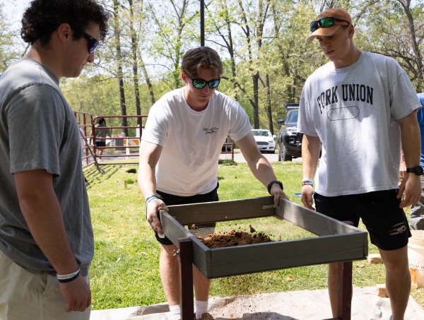 students sifting through sirt at the site of the excavation of Old College