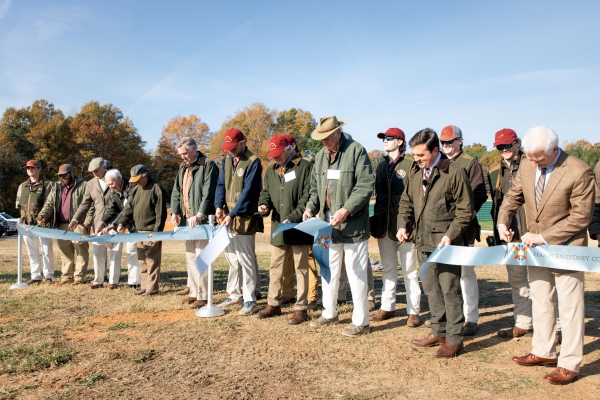 a large group gathers in a field for the Slate Hill Shooting Range ribbon-cutting