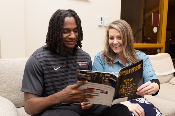 Michele King and student looking at a magazine