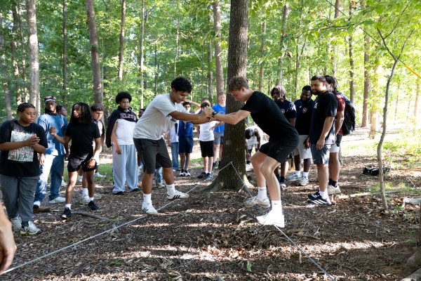 prospective students working together on a low ropes course