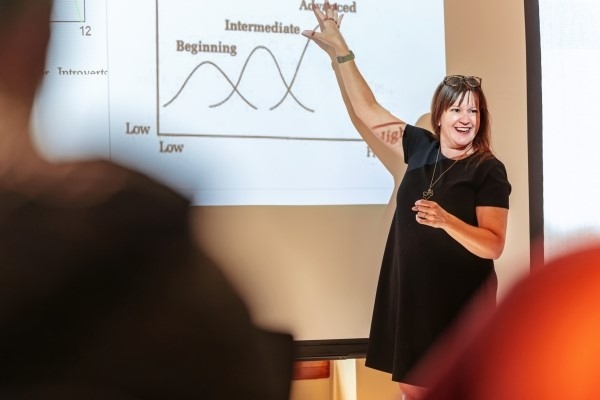 Professor Jenn Vitale in front of a projection giving a lecture