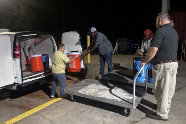 Staff loading coolers of water into a truck