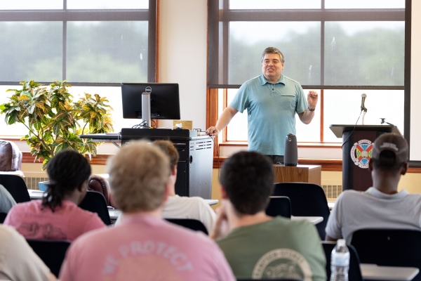 Dr. Wolyniak speaking in front of students in a large room