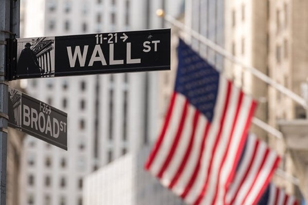 The Wall Street sign and the American flag in the background