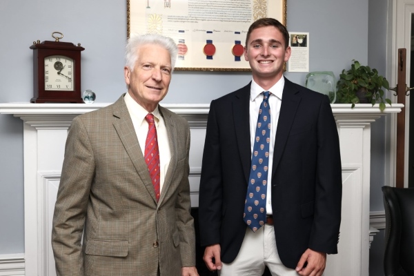 Kayne Wooten and President Stimpert standing in front of a hearth