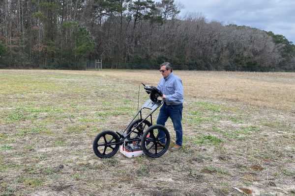 Carter Hudgins pushing equipment on a plantation plot