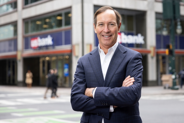 Dee O’Dell ’87 standing in front of a bank