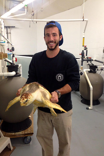 Nick DeProspero holding a sea turtle