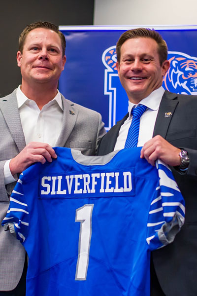 Coach Ryan Silverfield holding a football jersey
