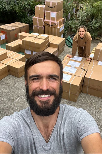 Yevhen (Zhenya) Goncharov posing in front of stack of Amazon.com boxes