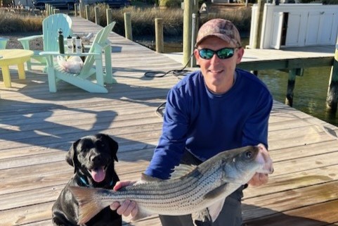 Rick Godsey holding a fish he caught with his dog