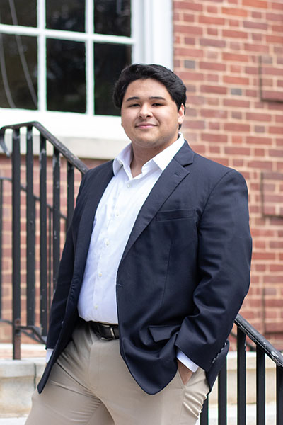 Elliot Williams' 25 standing in front of a campus building