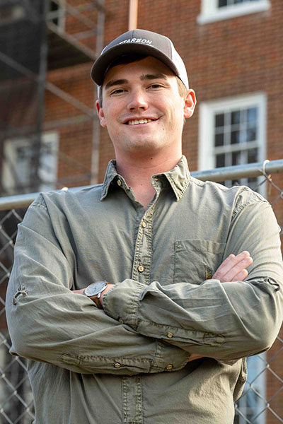 Drake James standing outside a construction site