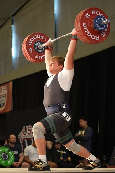 Logan Cohn '25 holding a barbell overhead