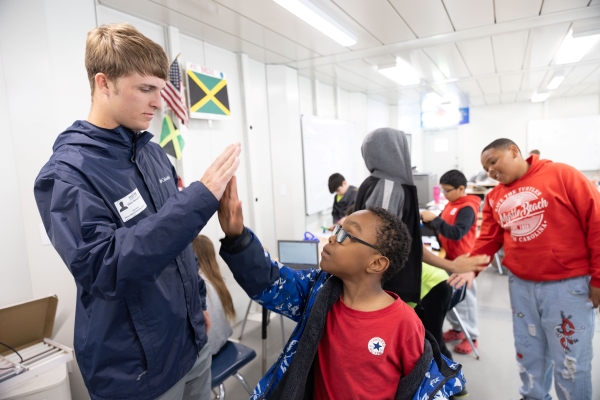 Dillon McReynolds high-fiving an elementary school child