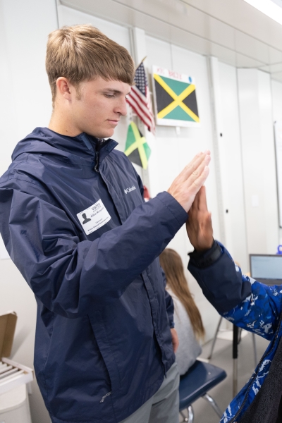 Dillon McReynolds high-fiving an elementary school child