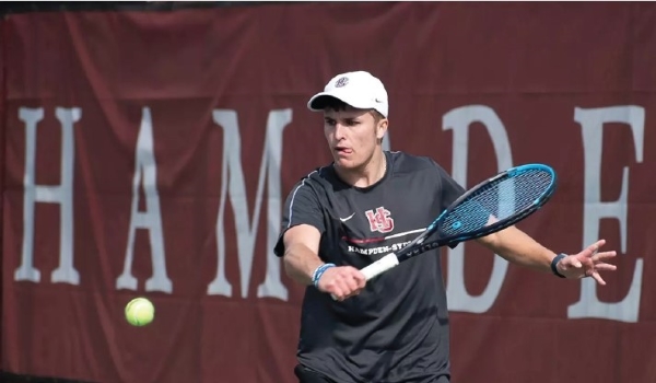 Dillon McReynolds serving a tennis ball on the court