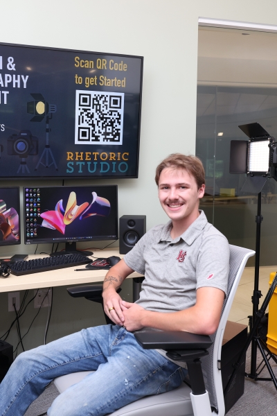 Haden VonCanon sitting at a Rhetoric Studio work station