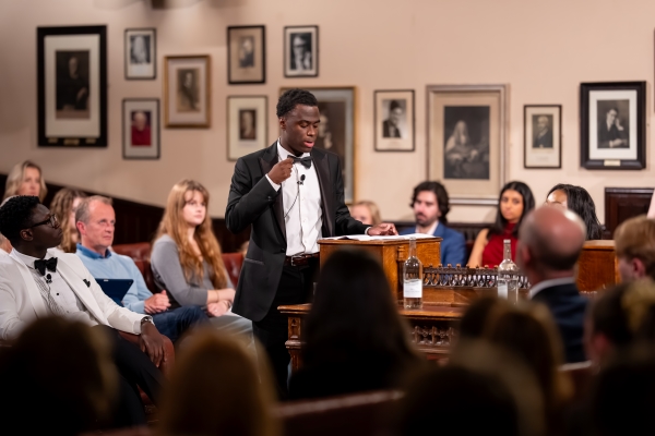 Kalefah Sirleaf speaking before a group of people at a debate event
