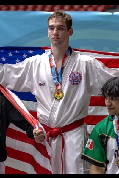 Ryan Sigsbee ’27 on the podium with the American flag behind him