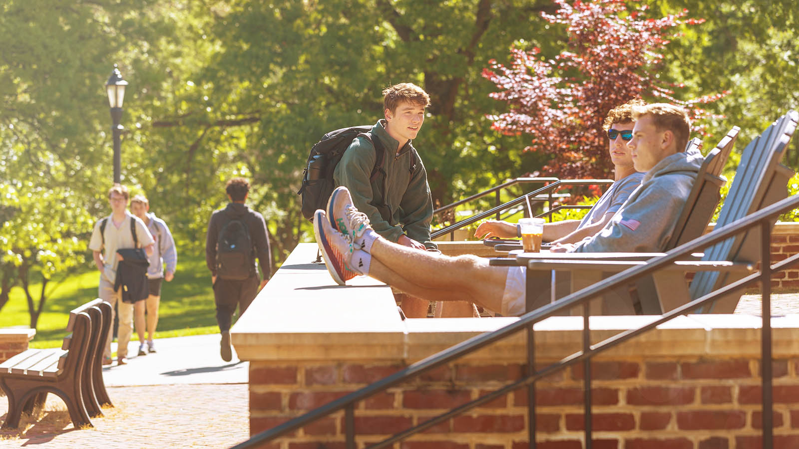 Students laughing and talking as they lounge on a terrace at Hampden-Sydney College.