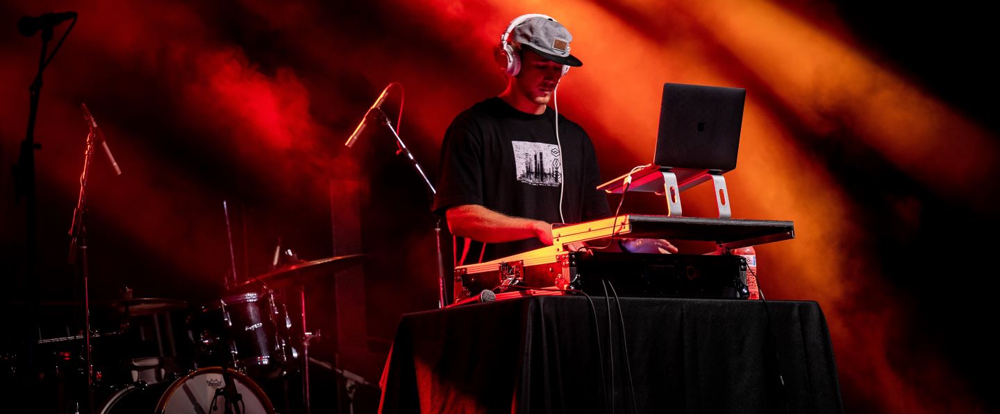 Hampden-Sydney College student surrounded by red light DJing at a party 