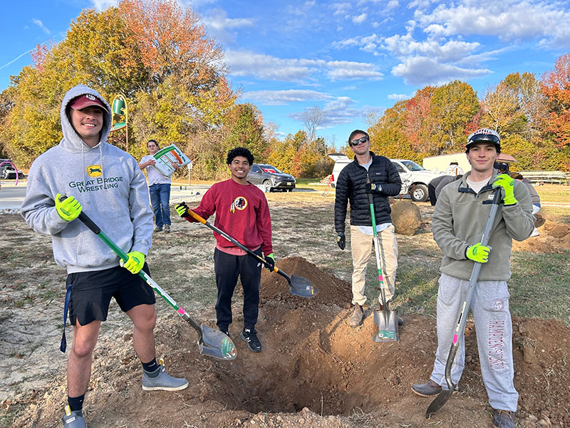stdents planting trees at a park