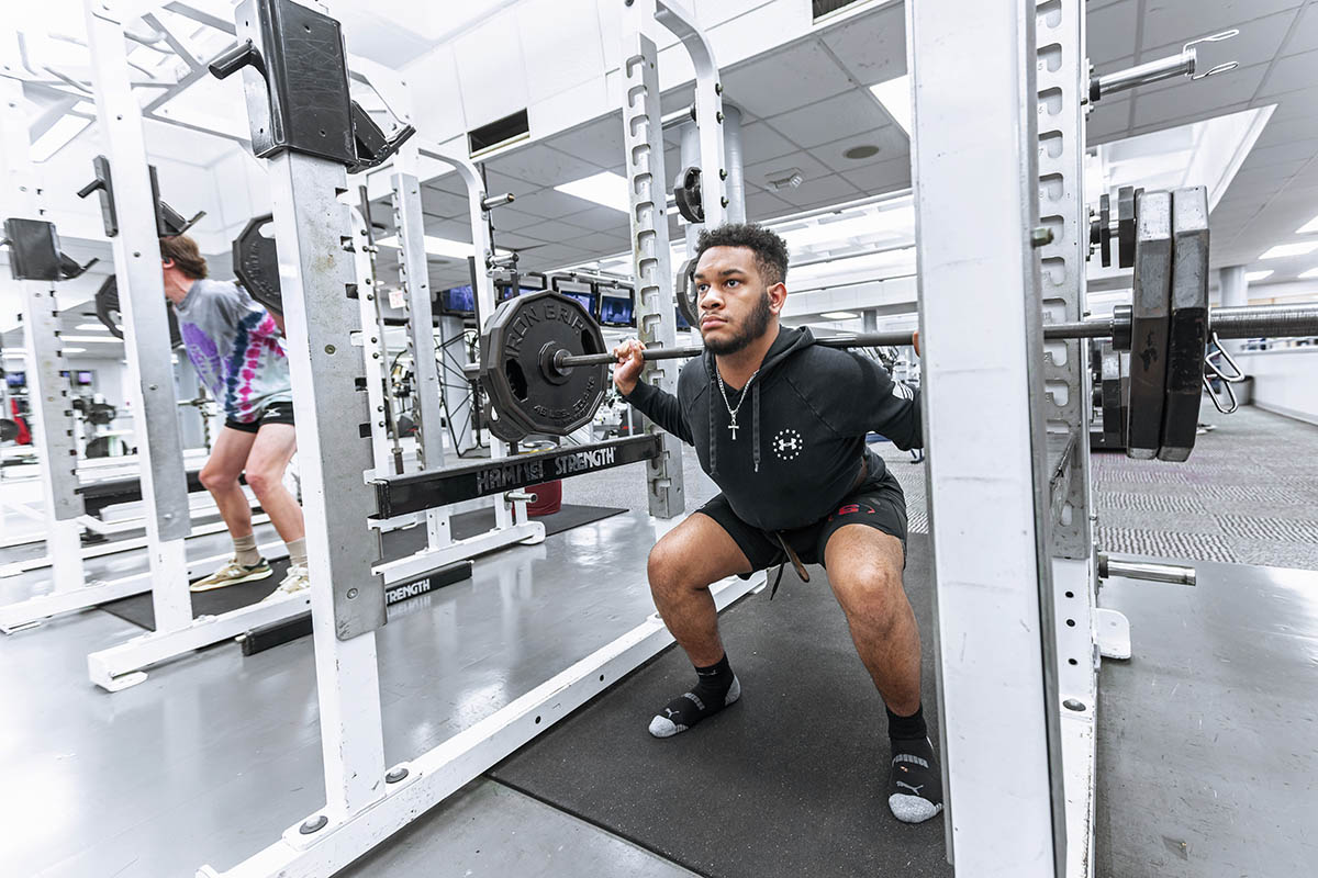 a student lifting weights in the gym