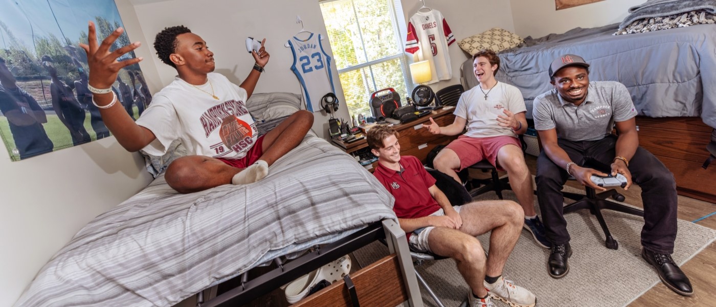 Students playing video games and hanging out in their dorm