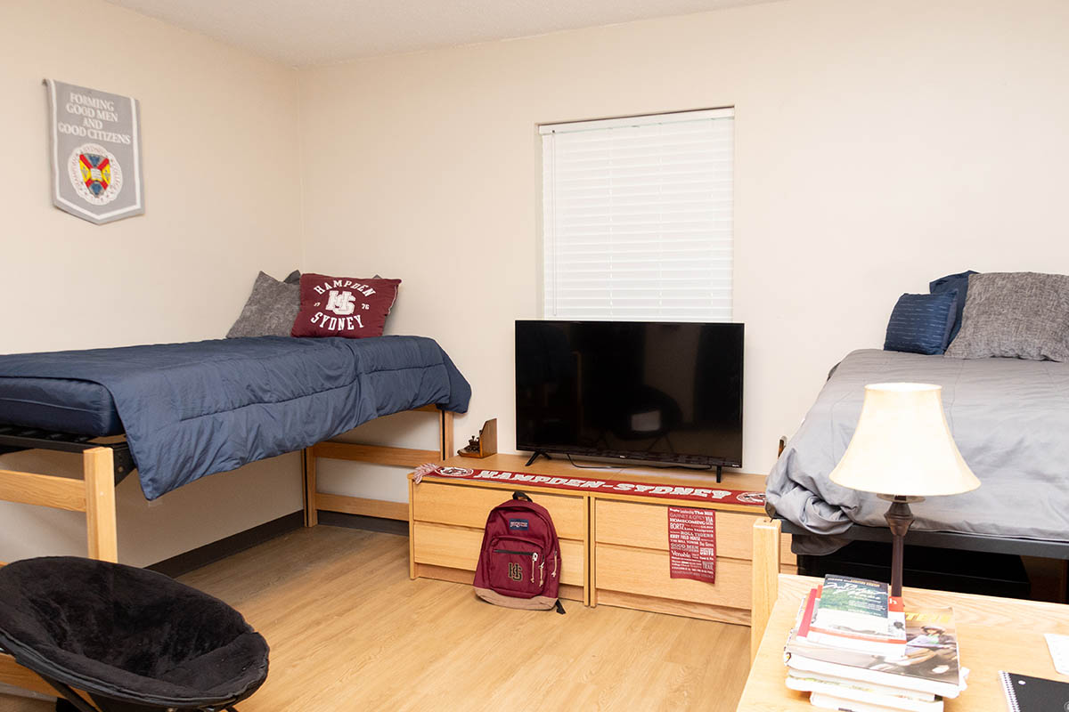 a bed and table inside a Carpenter residence hall dorm room