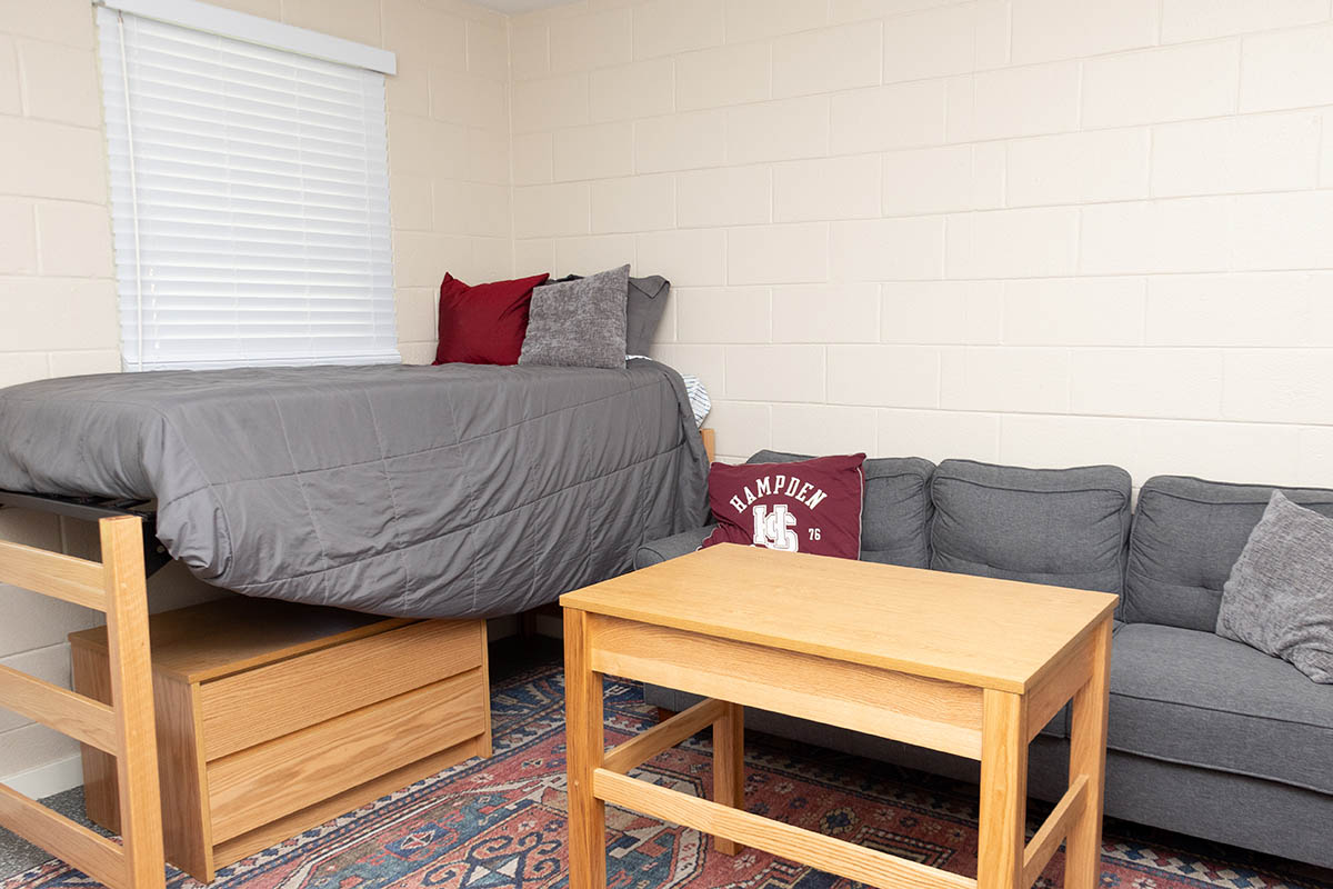a bed and a couch inside a dorm room in Whitehouse Hall