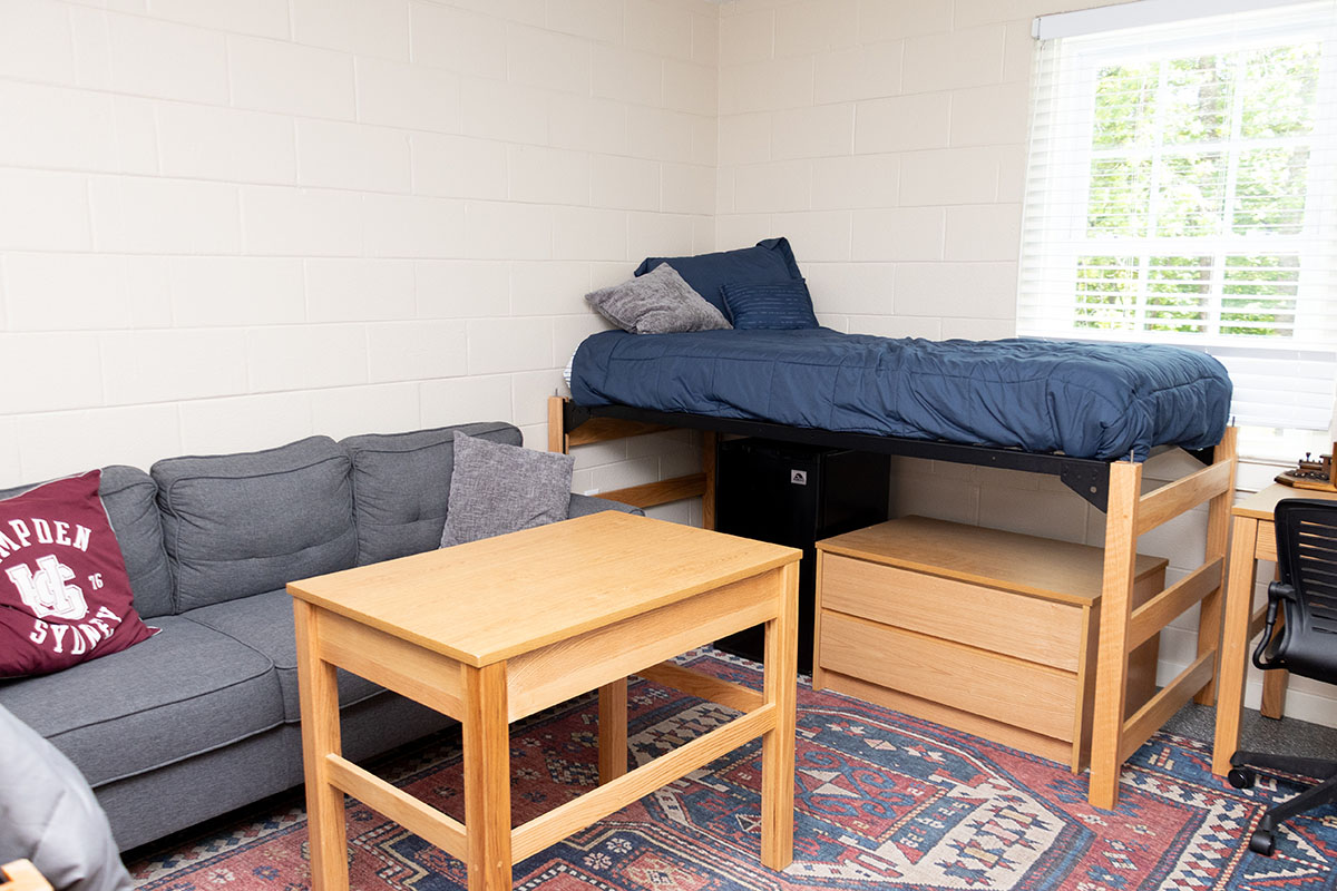 a bed and a couch inside a dorm room in Whitehouse Hall