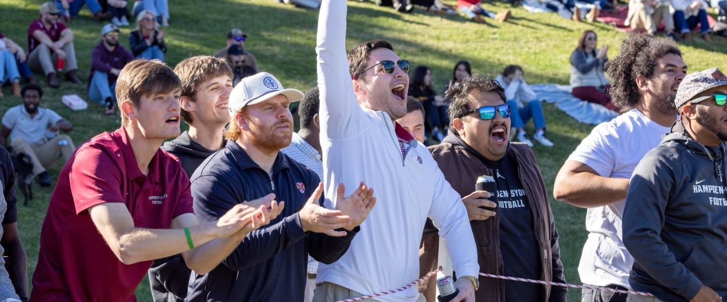 Friends cheering enthusiastically at a football game at Hampden-Sydney College