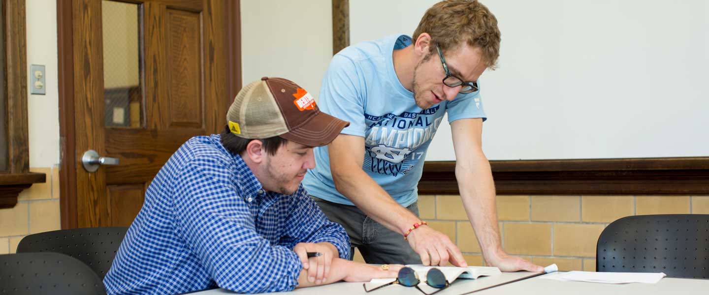 Perry helps a student in class