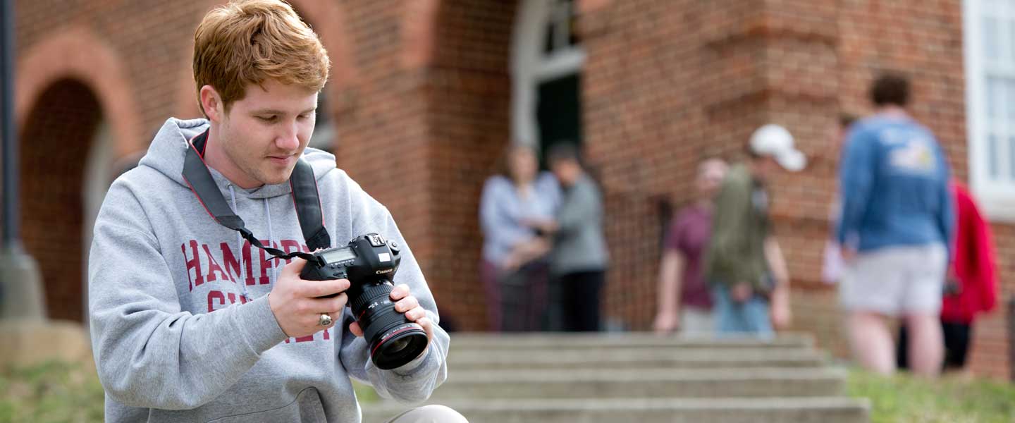 Student photographer outside Johns Auditorium at H-SC