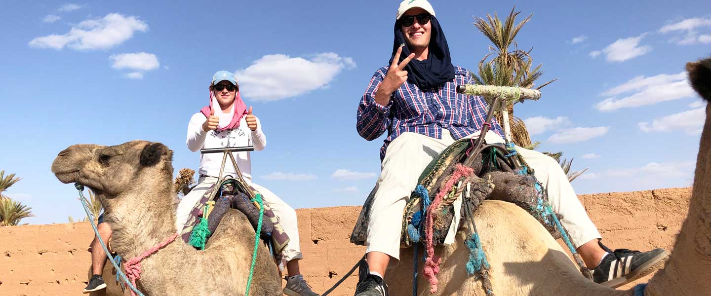 A Hampden-Sydney College student on a camel in the Middle East desert