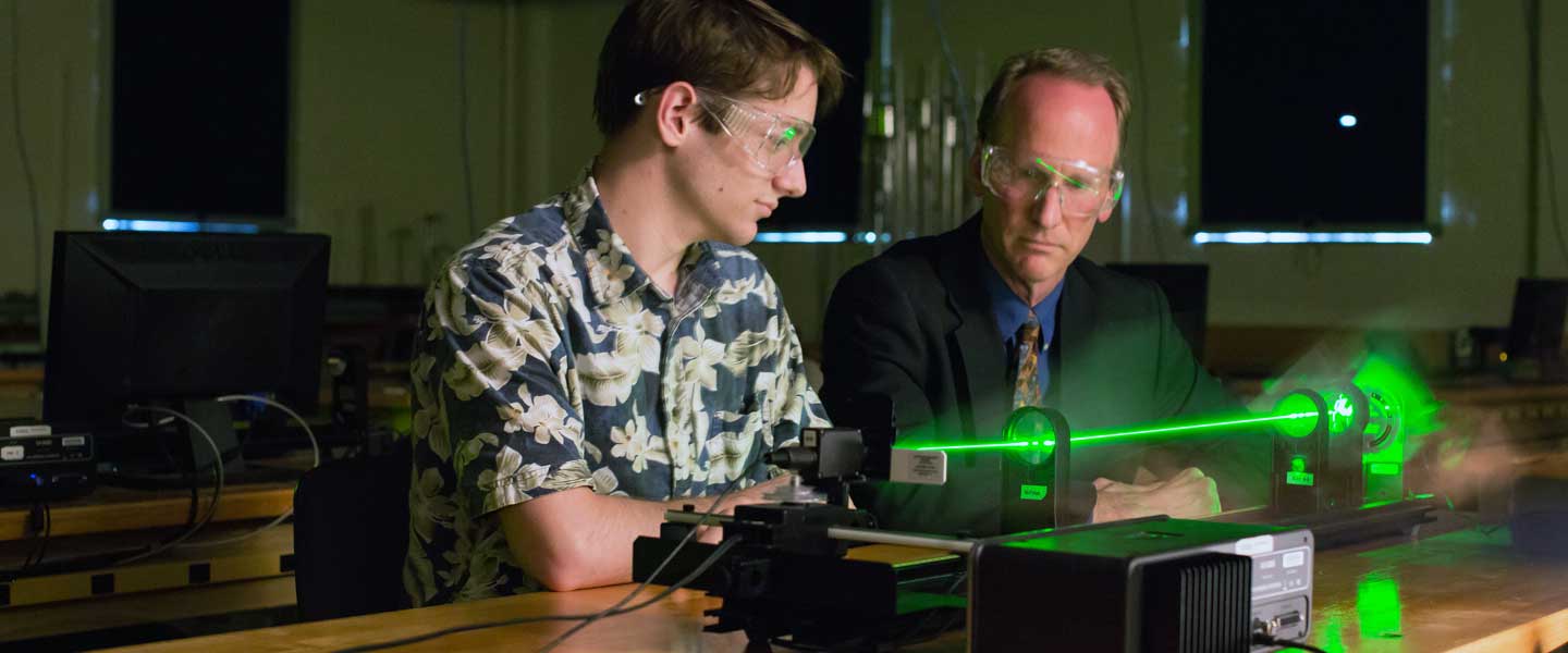 Professor Cheyne and physics student operating a laser