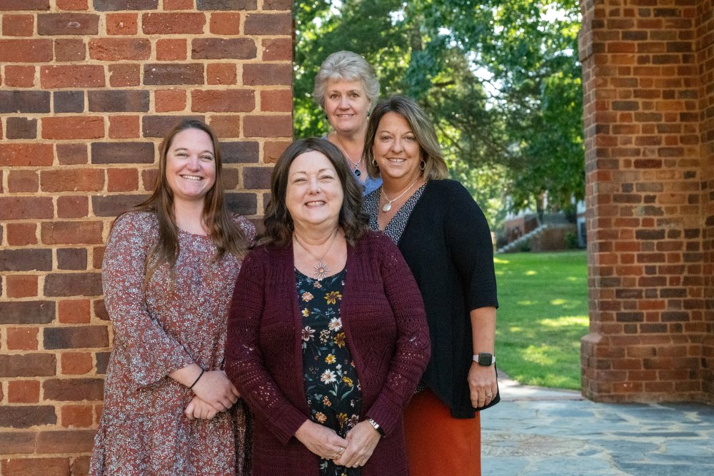 Four members of the financial aid staff standing outside