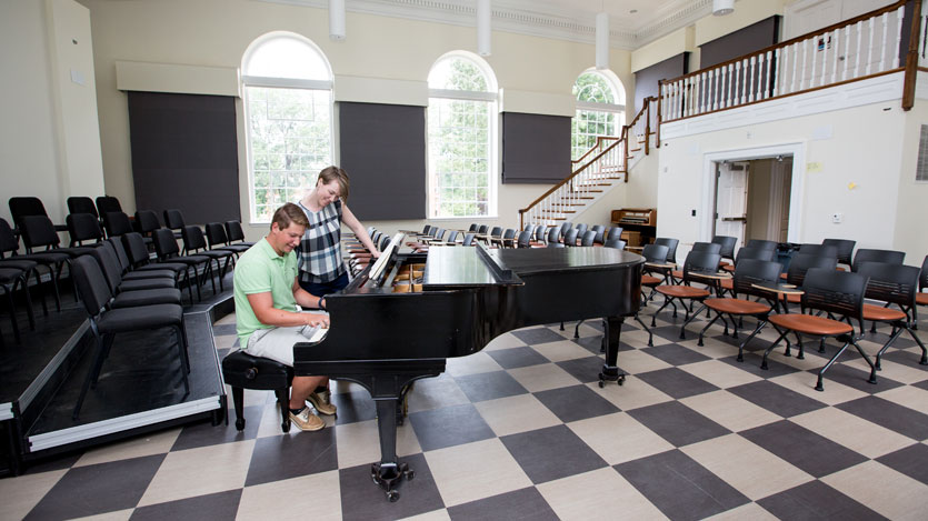 Professor von Rueden at a practice piano in the choral hall with a student