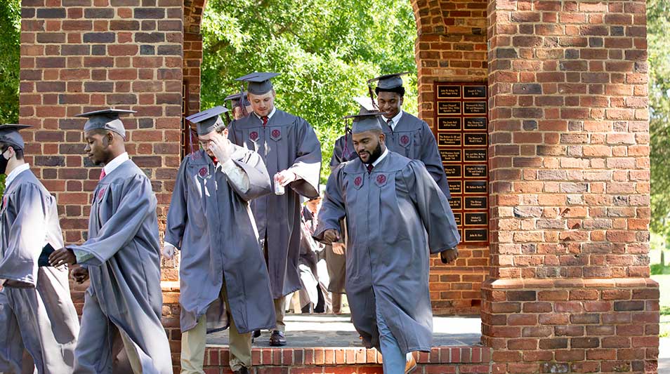Commencement 2021 graduates in regalia process through the Bell Tower