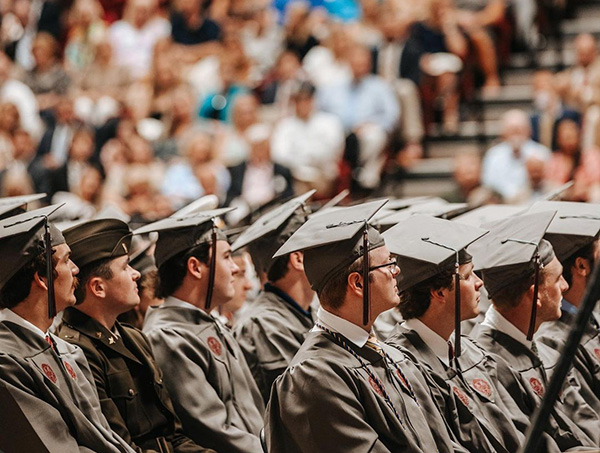 students in full regalia sitting together during the commencment ceremony