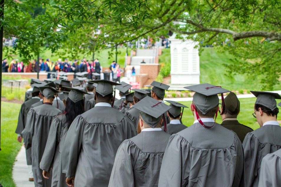 Commencement 2023 graduates in regalia processing